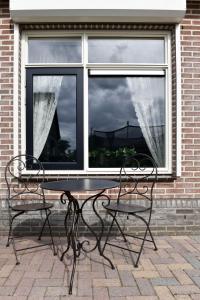 a table and two chairs in front of a window at Levenslust Hulshorst in Hulshorst