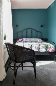 - une chambre avec un lit aux murs bleus et un banc dans l'établissement Levenslust Hulshorst, à Hulshorst