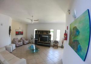 a living room with a couch and a tv at Pousada Etoile in Juquei