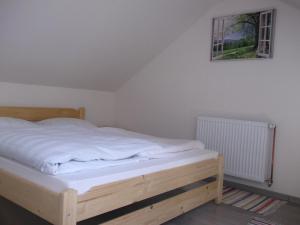 a bedroom with a wooden bed with a picture on the wall at Török Kulcsosház in Băile Homorod