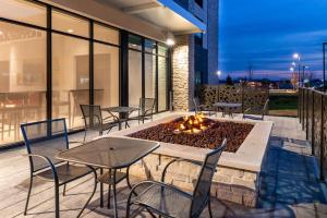 a patio with tables and chairs and a fire pit at Holiday Inn Express & Suites - Romeoville - Joliet North by IHG in Romeoville