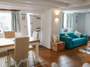 ein Wohnzimmer mit einem Tisch und einem blauen Sofa in der Unterkunft Furneaux Hatch in Kingsbridge