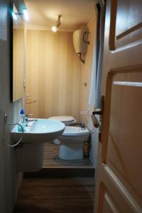 een badkamer met een toilet, een wastafel en een deur bij Dante's Room by Apulia Accommodation in Bari