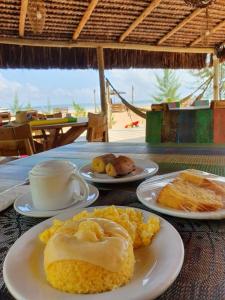 un tavolo con piatti di cibo e una tazza di caffè di Pôr do Sol Eco Suítes a Barra Grande Altre 60 foto