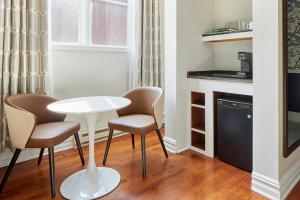 een kleine keuken met een witte tafel en 2 stoelen bij The Arco powered by Sonder in Philadelphia