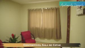 a room with a red chair and a window at Terra D` Ouro Apart Hotel in São João del Rei