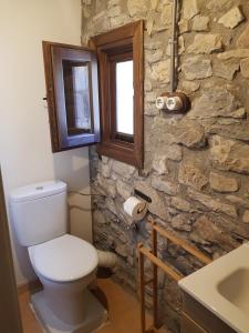 baño con aseo y pared de piedra en PALLERO BAIXO, en Las Colladas 35 fotos más