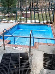 a swimming pool with a metal railing around it at Rib Mountain Inn in Wausau