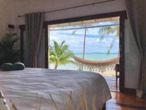 ein Schlafzimmer mit Bett und Blick auf das Meer in der Unterkunft Mangata Boutique Bungalows in Srithanu
