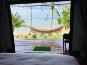 Schlafzimmer mit Hängematte und Strandblick in der Unterkunft Mangata Boutique Bungalows in Srithanu