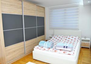ein kleines Schlafzimmer mit einem Bett und einem Fenster in der Unterkunft Apartman Lizdek in Pale