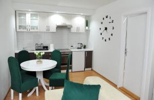 a kitchen with a table and green chairs in a room at Apartman Lizdek in Pale