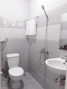 a white bathroom with a toilet and a sink at Nhà nghỉ 89 in Phan Thiet +11 photos