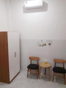 a room with two tables and two stools and a heater at Nhà nghỉ 89 in Phan Thiet