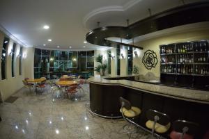 a restaurant with a bar with tables and chairs at Barbur Plaza Hotel in Ponta Grossa