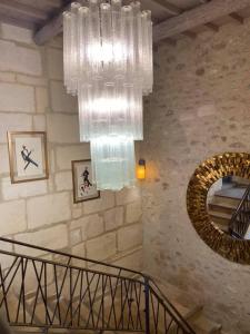 a large chandelier hanging in a room with a staircase at Domaine Cap Rubis in Paradou