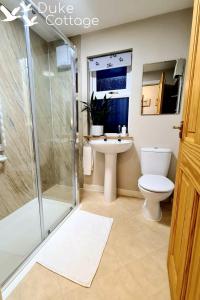 a bathroom with a shower and a toilet and a sink at Duke Cottage in Fochabers