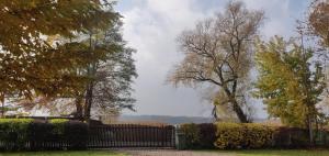 una valla en un parque con árboles y arbustos en Lakeside Cottage, en Sajzy