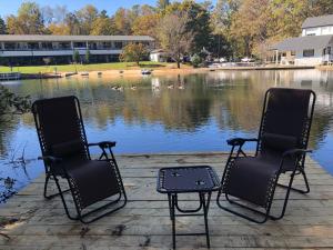 two chairs sitting on a dock next to a lake at Mill House Lodge - Flat Rock in Hendersonville