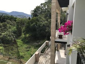 - un balcon d'une maison ornée de fleurs roses dans l'établissement Departamento con espectacular vista a la montaña., à Puerto Vallarta