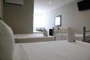 a hotel room with two beds and a window at Hotel Florencia Poza Rica in Poza Rica de Hidalgo