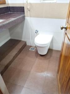 a bathroom with a toilet and a sink at Hotel Chembiyan in Pudukkottai