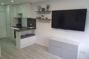 a living room with a flat screen tv on a wall at Entire Apartment! 2 double beds, sleeps upto 4 in Oldbury