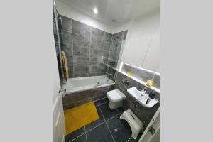 a bathroom with a toilet and a sink and a tub at Entire Apartment! 2 double beds, sleeps upto 4 in Oldbury