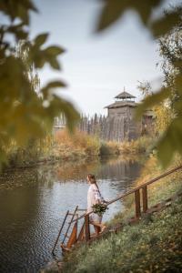 een vrouw die op een brug over een rivier staat bij HOT SPRINGS in Soezdal