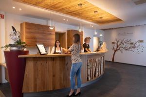 a woman is standing at a counter at a bar at Kohlers Hotel Engel in Bühl