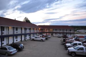 un gran aparcamiento frente a un motel en Blue Bell Inn, en Fort Nelson