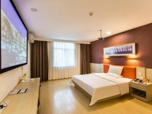 pokój hotelowy z łóżkiem i telewizorem z płaskim ekranem w obiekcie 7Days Inn Suzhou Park New Area Commercial Street w mieście Suzhou