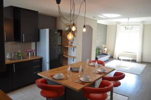 a kitchen with a wooden table and red chairs at Le Saint-Bernard in Metz
