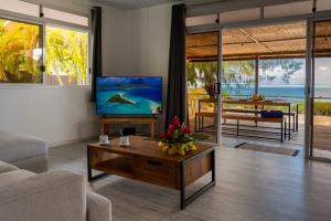 salon z telewizorem i stołem w obiekcie Matira Sandy Home 658 DTO-MT w mieście Bora Bora