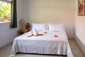 Un dormitorio con una cama blanca con flores. en Matira Sandy Home 658 DTO-MT, en Bora Bora