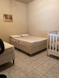 - une chambre avec 2 lits et un lit bébé dans l'établissement Sítio Alvorada - Paraíso localizado no Circuito das Águas Paulista, à Amparo