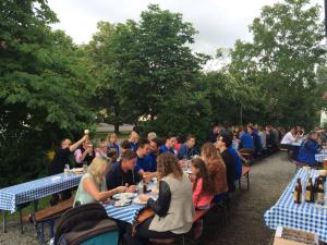 a group of people sitting at tables in a garden at Gasthaus zum Späth in Englmannsberg