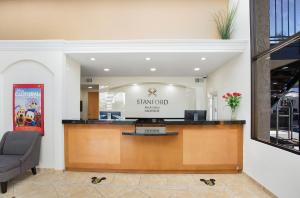 a hotel lobby with a desk with a sign on it at Stanford Inn & Suites Anaheim in Anaheim