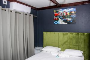 una camera da letto con un letto e un quadro sul muro di Shanduka Country Lodge a Thohoyandou