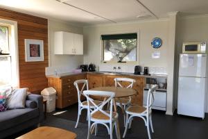 a kitchen with a table and chairs in a kitchen at BINALONG BEACH COTTAGE Beachfront at Bay of Fires Next to Restaurant in Binalong Bay
