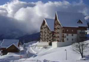a large building in the snow next to a mountain at Appartement cosy 27 m2 idéal 5 personnes in Saint-François-Longchamp