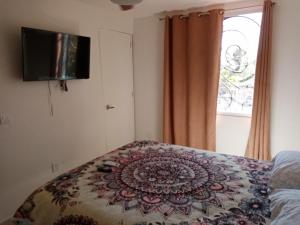 Un dormitorio con una cama con una manta de flores. en Casa Margarita Rooms available, en Bucerías
