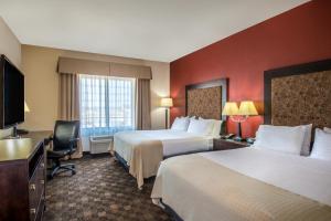 a hotel room with two beds and a flat screen tv at Holiday Inn Hotel & Suites Grand Junction-Airport, an IHG Hotel in Grand Junction