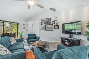 ein Wohnzimmer mit blauen Sofas und einem TV in der Unterkunft Barsl Retreat in Cape Coral