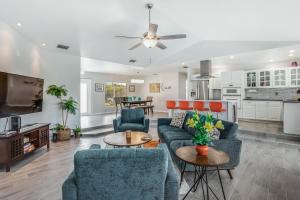 a living room with two blue couches and a kitchen at Barsl Retreat in Cape Coral