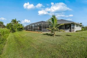 a house with a palm tree in front of a yard at Barsl Retreat in Cape Coral