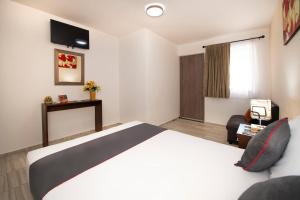 Hotel Quinta Las Fuentes Bernal في برنال: غرفه فندقيه بسرير وكرسي