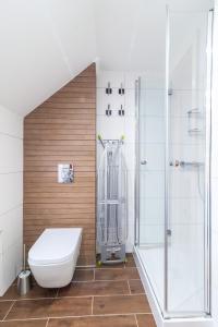 a bathroom with a toilet and a shower at Apartament NaFali in Niechorze +46 photos