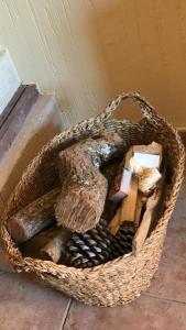a basket filled with wood and other items on a floor at Alojamiento rural "LA JARA" in Robledillo de la Jara