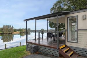 a house with a deck with a view of a lake at Discovery Parks - Forster in Tuncurry